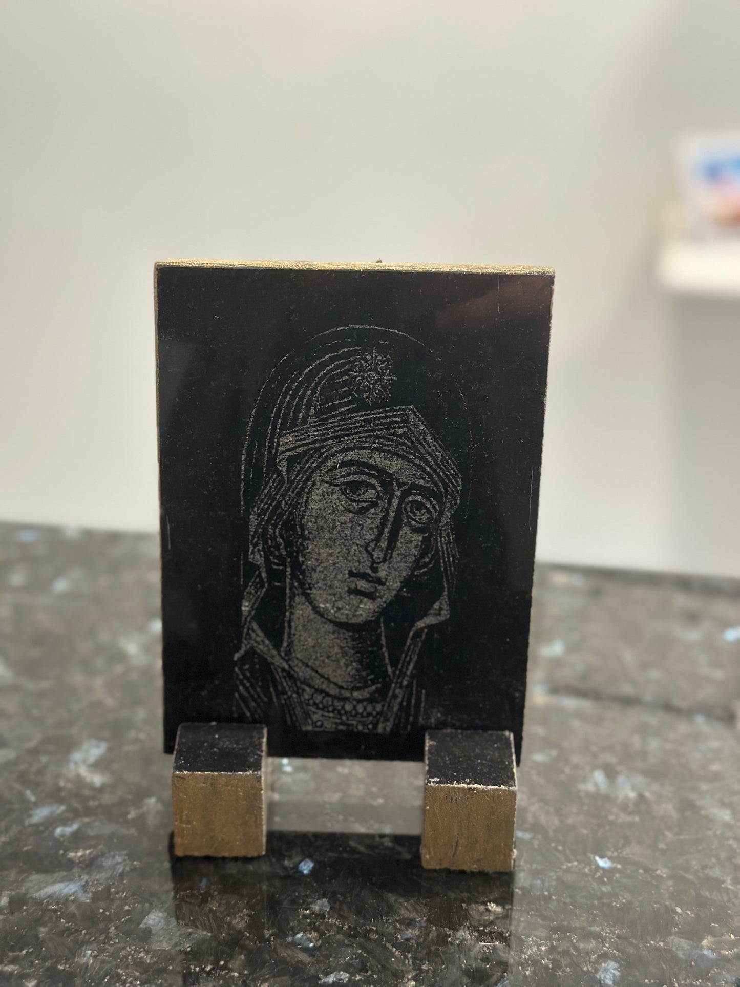 Icon of the Virgin Mary engraved on black granite