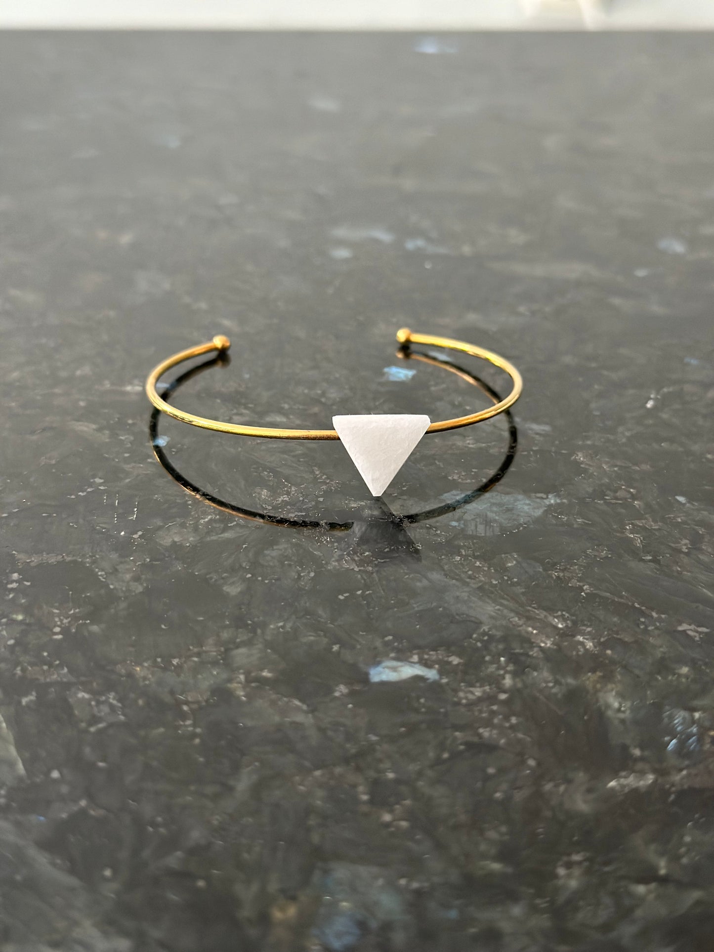 Gold-colored bracelet with white marble triangle