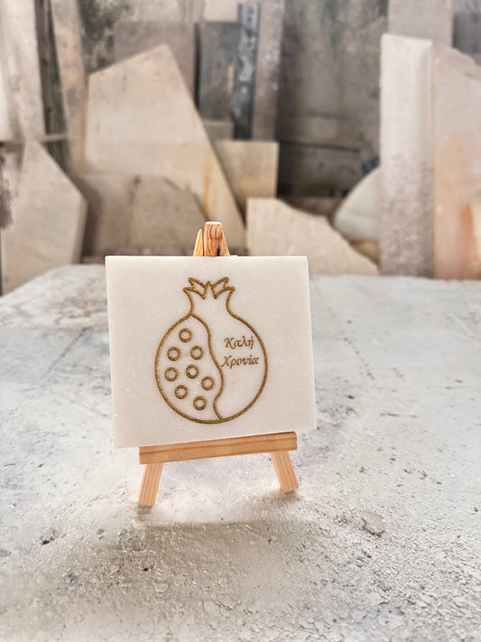 Good luck pomegranate charm engraved in white marble with gold letters and wooden base