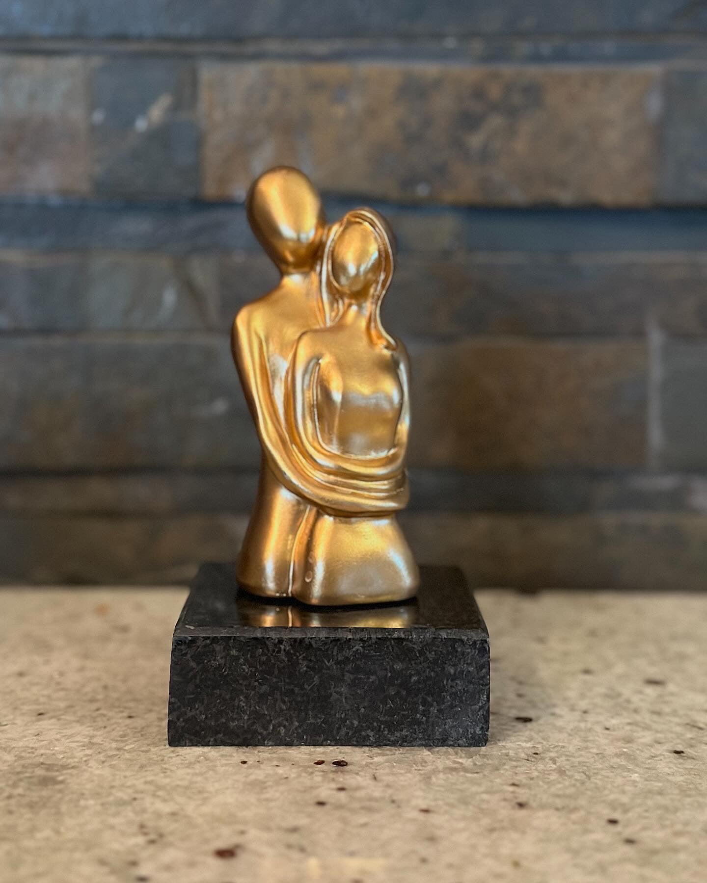 Χρυσές φιγούρες ζευγαριού πάνω σε μαύρο γρανίτη