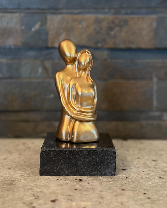 Χρυσές φιγούρες ζευγαριού πάνω σε μαύρο γρανίτη