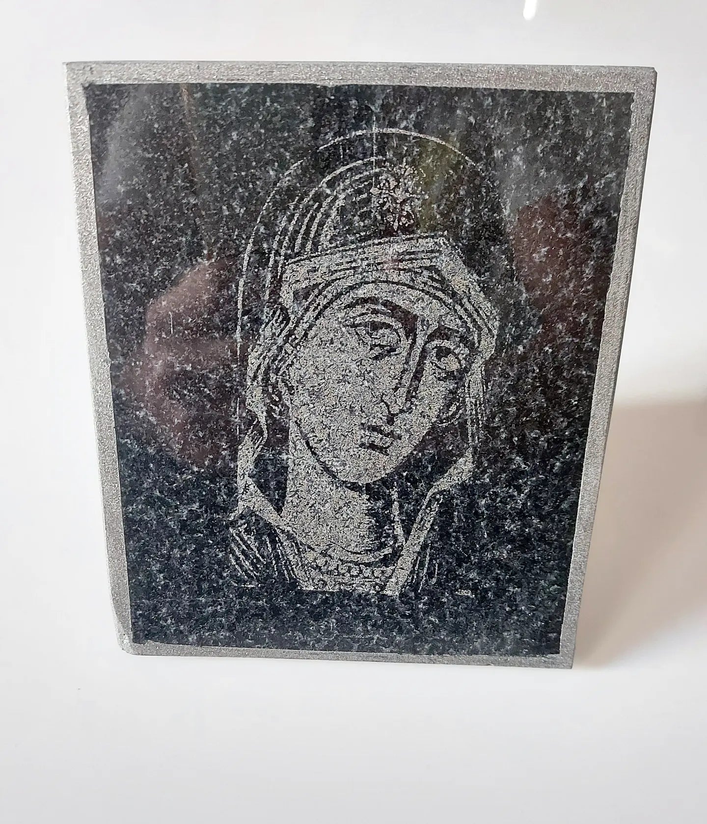 Icon of the Virgin Mary carved on black granite. Dimensions 12*15