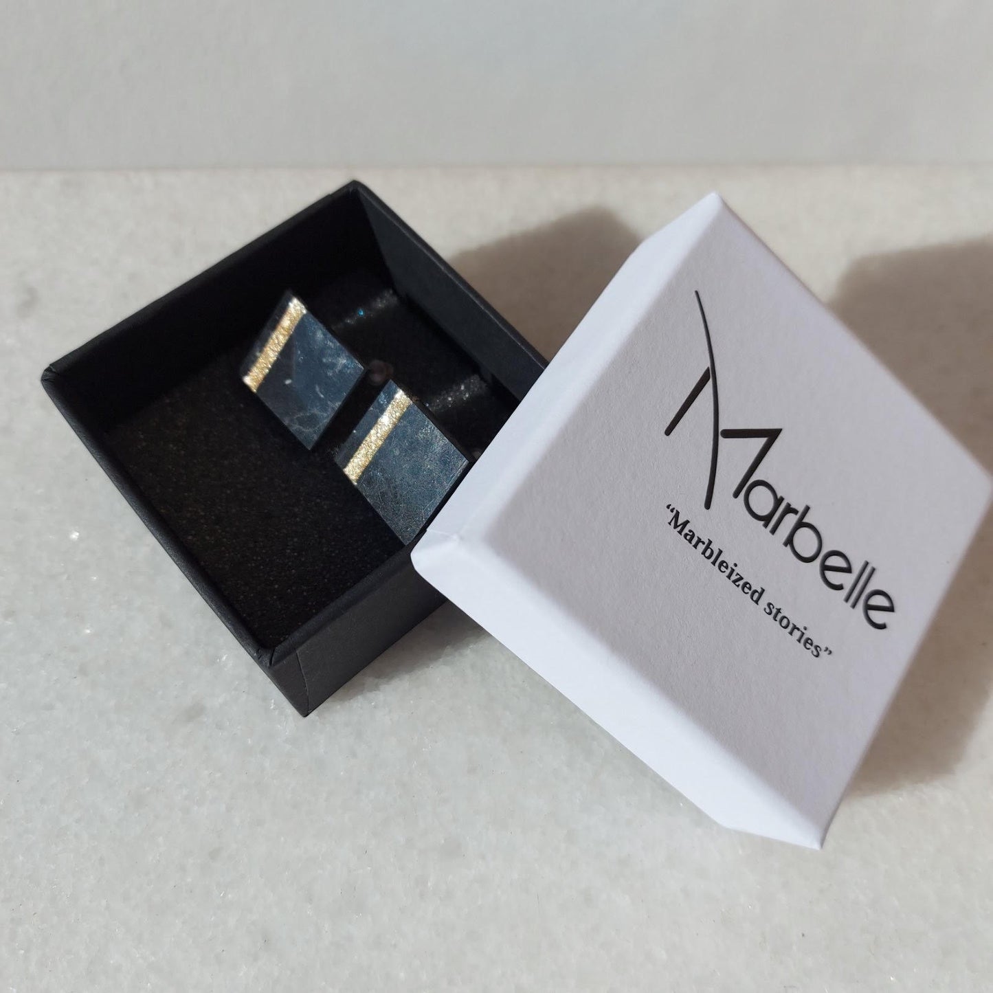 Square black granite stud earrings with gold detail